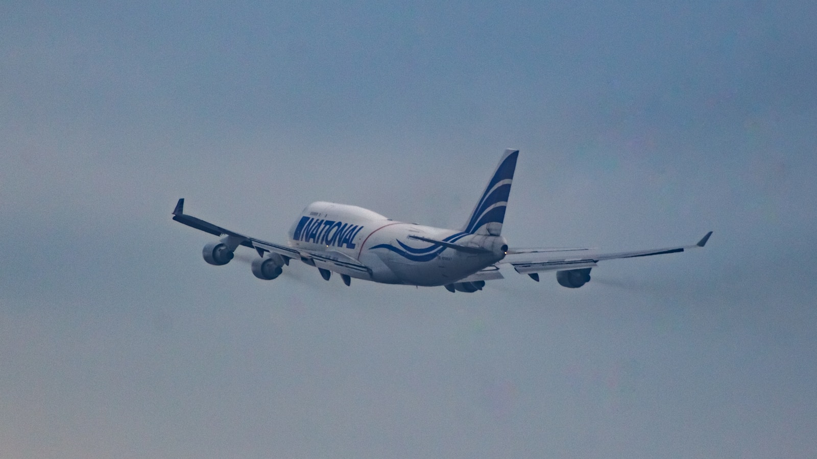 a large jetliner flying through a cloudy blue sky